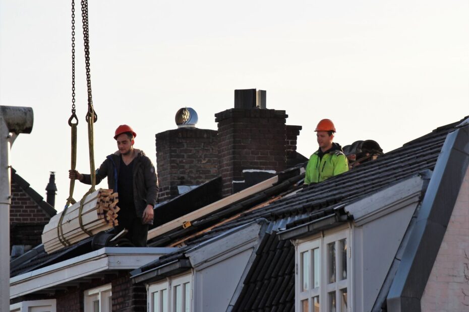 Workers operate on a rooftop under construction in the Netherlands, showcasing teamwork and safety.